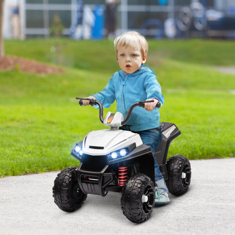 Front view of white kids ATV showing realistic LED lights and rugged wheels
