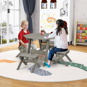 Two children sitting at a small wooden table in a room with a large window and colorful wall art.